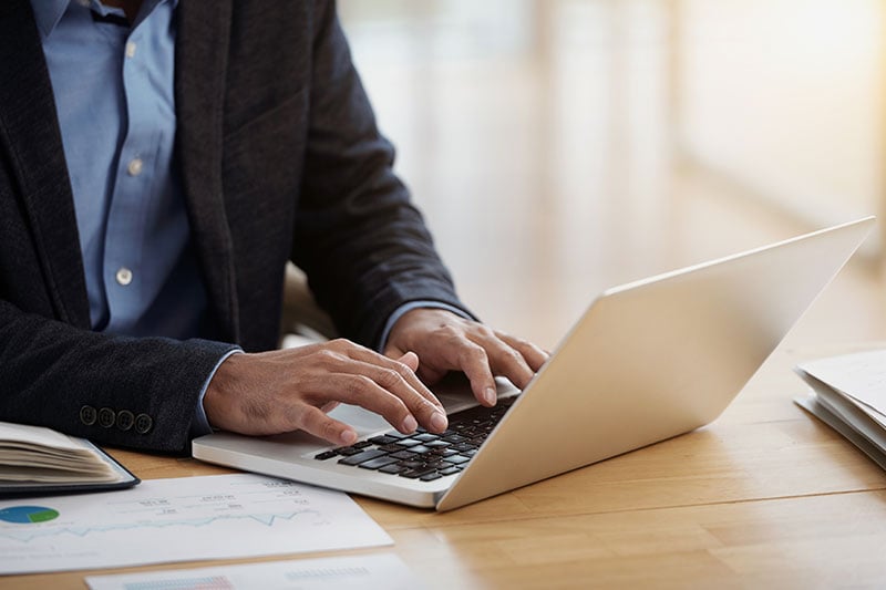 A man working on sales presentations and  testimonials on his laptop.